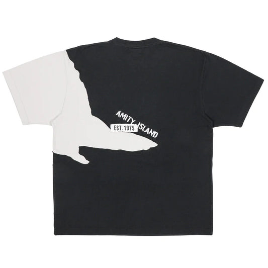 A black and white color-blocked t-shirt from the USJ UNIVRS collection. The shirt features a large graphic of the shark from Jaws with the word 'JAWS' printed below it.