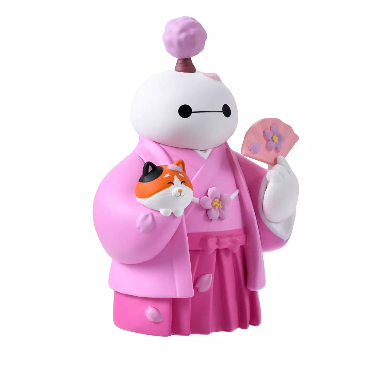 An adorable figure of Baymax from Big Hero 6 dressed in a traditional pink kimono and hakama for the cherry blossom season. Baymax holds a pink fan with a flower design in one hand and cradles Mochi the cat (also smiling) in the other arm. A small cherry blossom tree sprouts from Baymax's head. The setting is a festive pink sakura background.