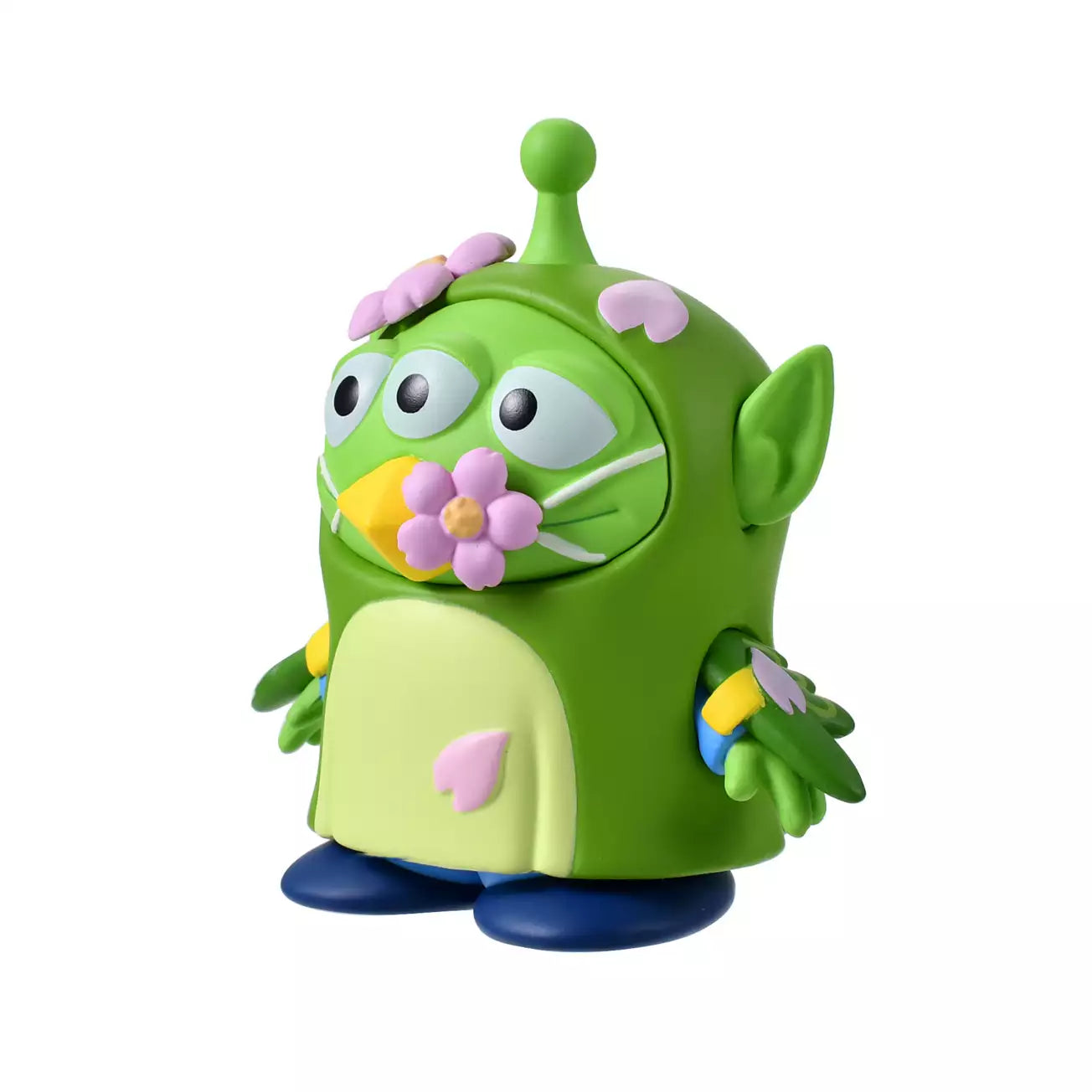 A whimsical figure of a Little Green Man (Alien) disguised as a Japanese Bush Warbler (Uguisu). The Alien is wearing a green bird costume with yellow beak details and blue accents on the wings. Pink cherry blossom flowers decorate the costume's head and beak. The figure stands in front of a scenic pink background with sakura motifs.