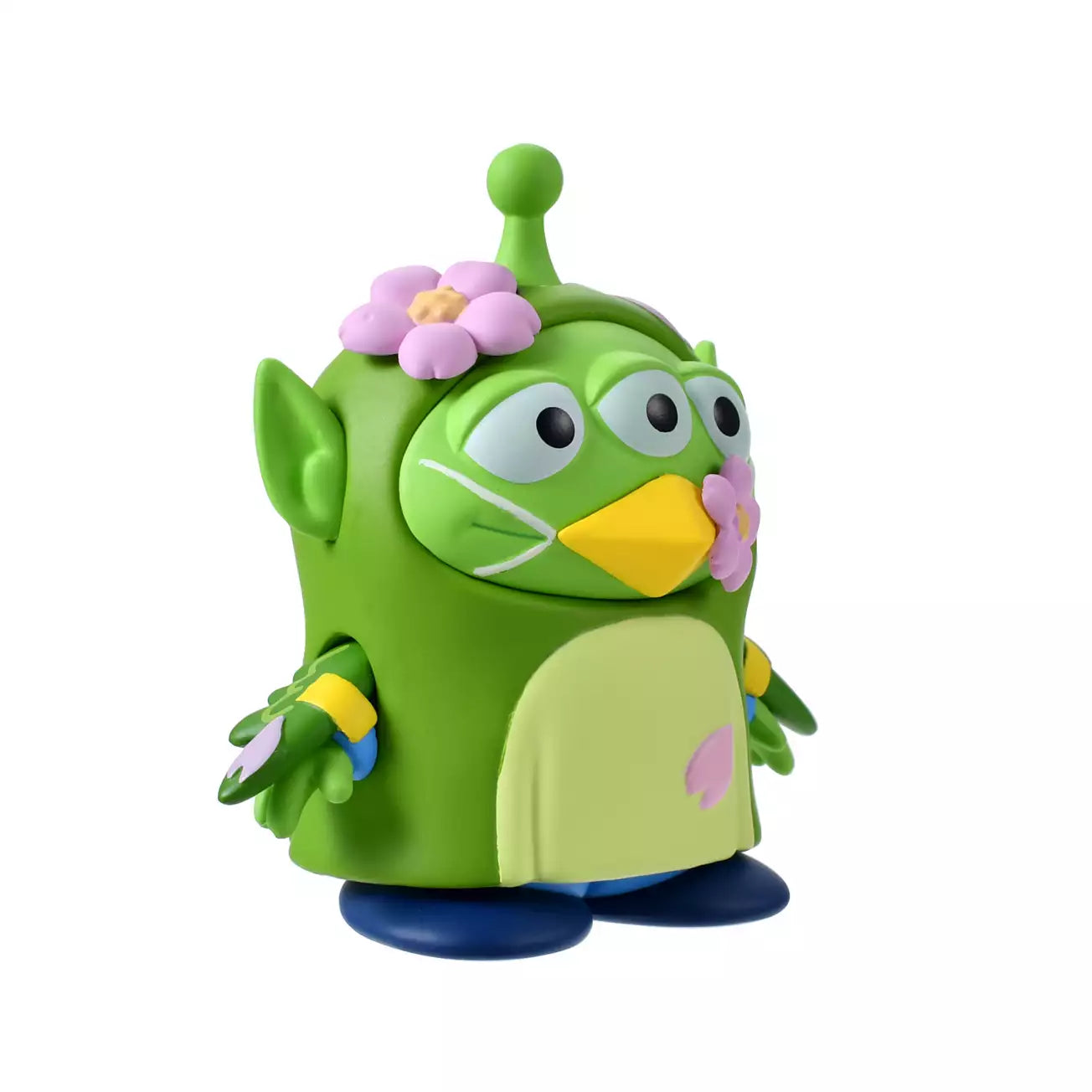 A whimsical figure of a Little Green Man (Alien) disguised as a Japanese Bush Warbler (Uguisu). The Alien is wearing a green bird costume with yellow beak details and blue accents on the wings. Pink cherry blossom flowers decorate the costume's head and beak. The figure stands in front of a scenic pink background with sakura motifs.