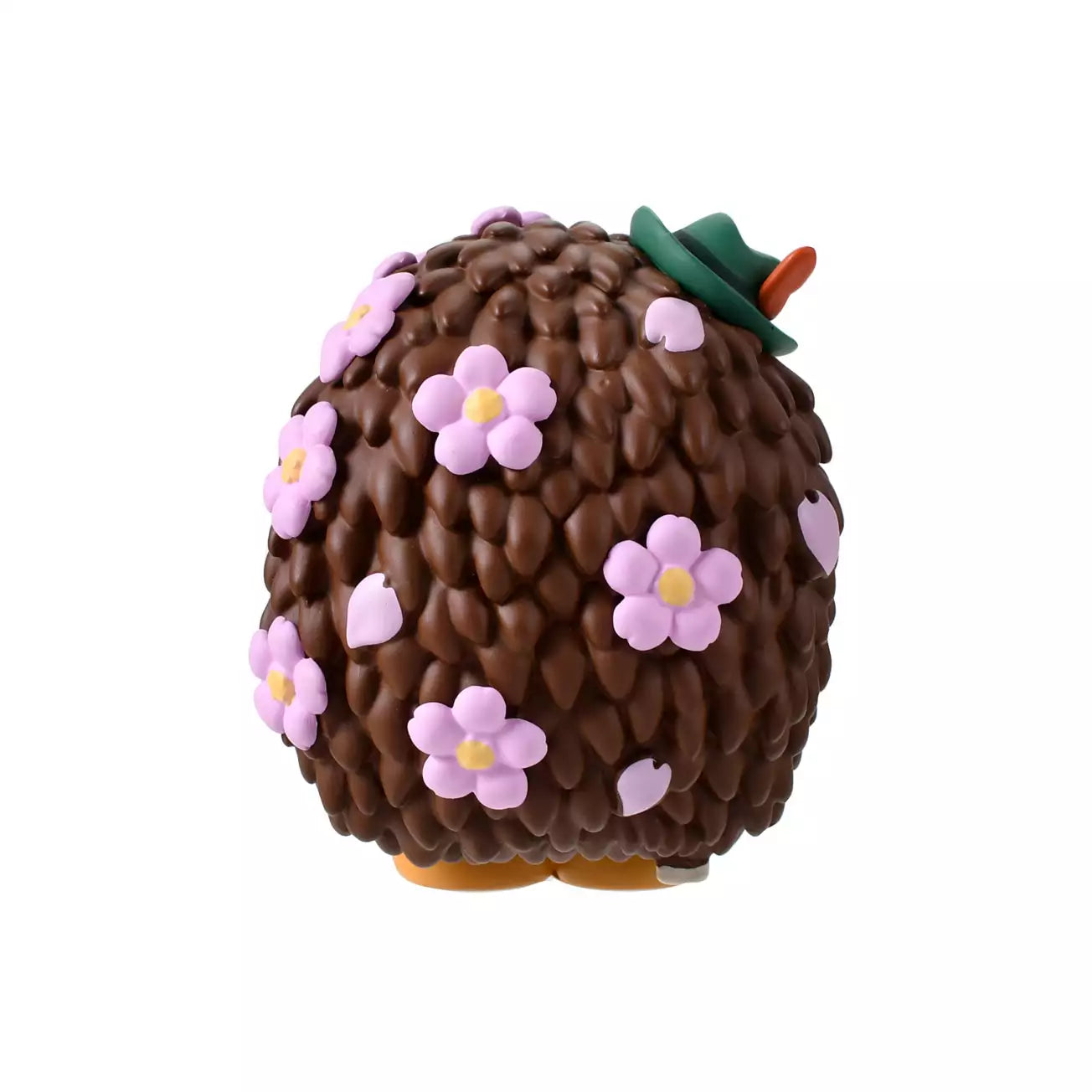 A figure of Mr. Pricklepants from Toy Story 3 enjoying a spring picnic. The hedgehog wears green lederhosen and a small green hat. He holds a 'Hanami Dango' (a three-colored sweet dumpling) in one hand and has a crown of pink cherry blossoms on his head. The background is pink with falling sakura petals.