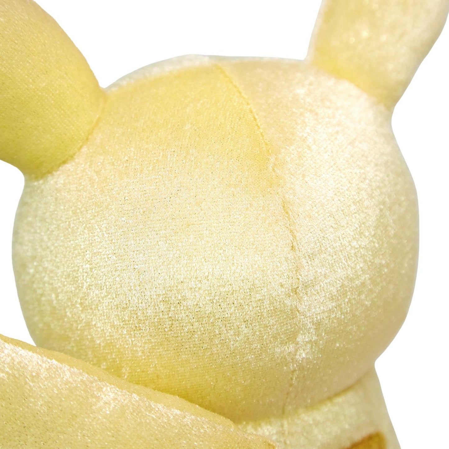 Close-up of the exclusive Pokémon 30th Anniversary Pikachu plush, showing the special golden 'Since 1996' woven tag and delicate glitter fabric.
