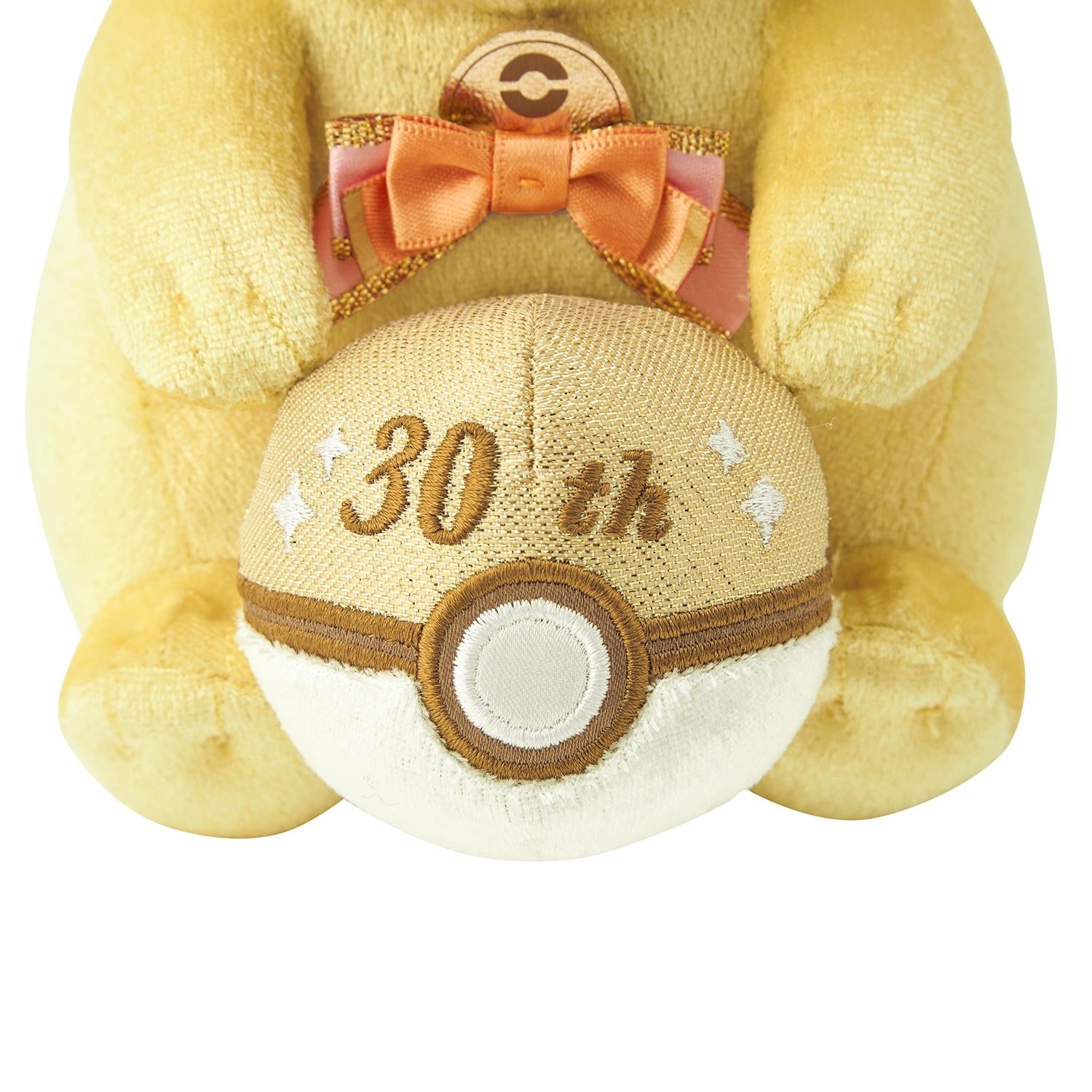 Close-up of the exclusive Pokémon 30th Anniversary Pikachu plush, showing the special golden 'Since 1996' woven tag and delicate glitter fabric.