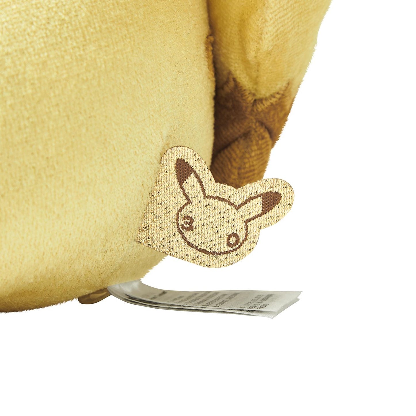 Close-up of the exclusive Pokémon 30th Anniversary Pikachu plush, showing the special golden 'Since 1996' woven tag and delicate glitter fabric.