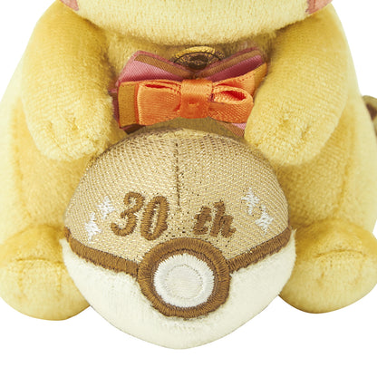 Close-up of the exclusive Pokémon 30th Anniversary Pikachu keychain, showing the special golden 'Since 1996' woven tag and delicate glitter fabric.
