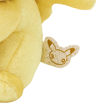 Close-up of the exclusive Pokémon 30th Anniversary Pikachu keychain, showing the special golden 'Since 1996' woven tag and delicate glitter fabric.