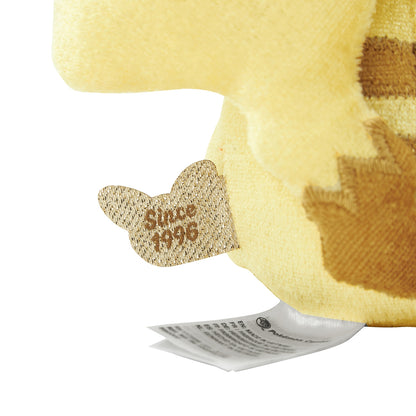 Close-up of the exclusive Pokémon 30th Anniversary Pikachu keychain, showing the special golden 'Since 1996' woven tag and delicate glitter fabric.