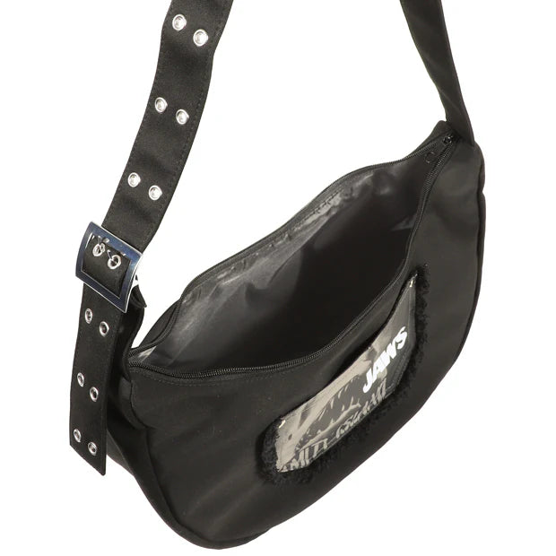 A black shoulder bag from the USJ UNIVRS collection featuring a pocket with a graphic of the shark from Jaws and the text 'JAWS' and 'AMITY ISLAND'.