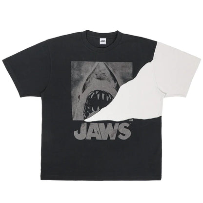 A black and white color-blocked t-shirt from the USJ UNIVRS collection. The shirt features a large graphic of the shark from Jaws with the word 'JAWS' printed below it.