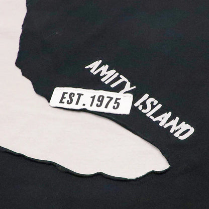 A black and white color-blocked t-shirt from the USJ UNIVRS collection. The shirt features a large graphic of the shark from Jaws with the word 'JAWS' printed below it.