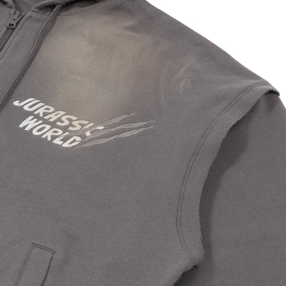 A grey zip-up hoodie from the USJ UNIVRS collection with a subtle graphic of a dinosaur scratching its claws and the text 'JURASSIC WORLD' on the front. The back features four vintage comic panels of dinosaurs.