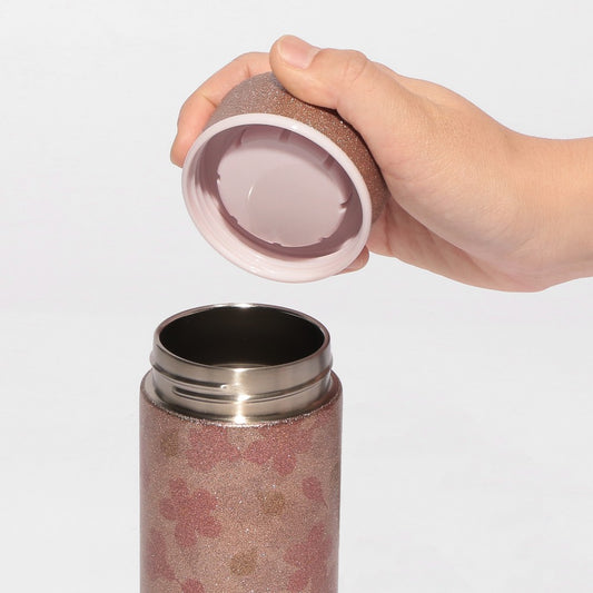 Starbucks Japan SAKURA Shine Brightly 2026 collection merchandise. Limited edition series featuring glitter pink stainless bottles, Stanley collaboration tumblers in pink gradient, and color-changing cups. The design theme highlights vivid spring colors, metallic gold accents, and bright cherry blossom patterns.